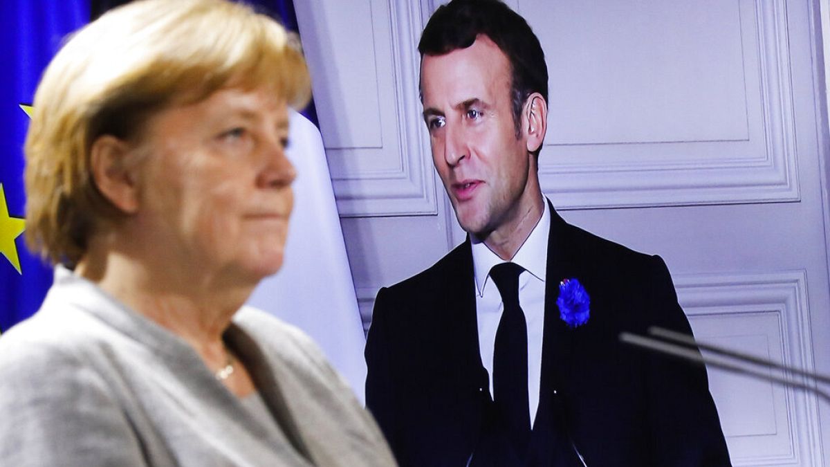 German Chancellor Angela Merkel listens to French president Emmanuel Macron, on the screen, during a virtual news conference with European leaders on terrorism