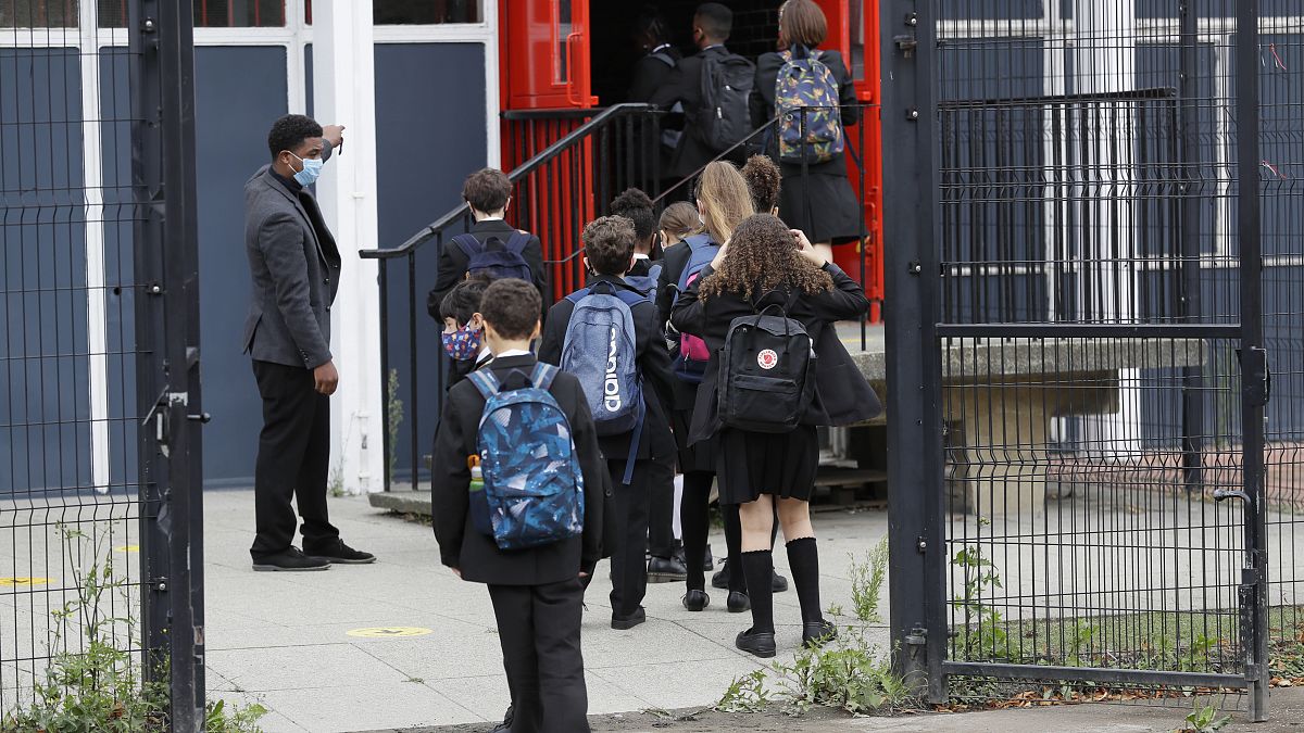 Year seven pupils are directed to socially distance as they arrive for their first day at Kingsdale Foundation School in London, Thursday, Sept. 3, 2020.