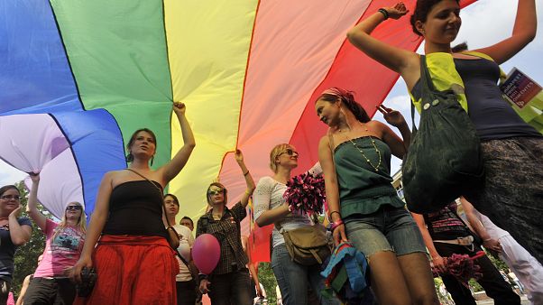 LGBT right activists march with a rainbow flag during the Gay Pride parade in Budapest. LGBT right activists march with a rainbow flag during the Gay Pride parade in Budapest.