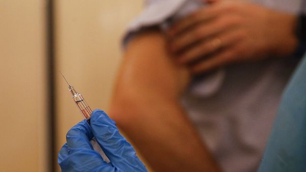 A nurse prepares to inject flu vaccine Jacopo Leoni at the Museum of science and technology in Milan, Italy, Wednesday, Nov. 4, 2020. 