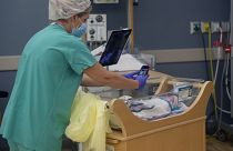 Медсестра фотографирует новорождённого для изолированной из-за Covid-19 матери