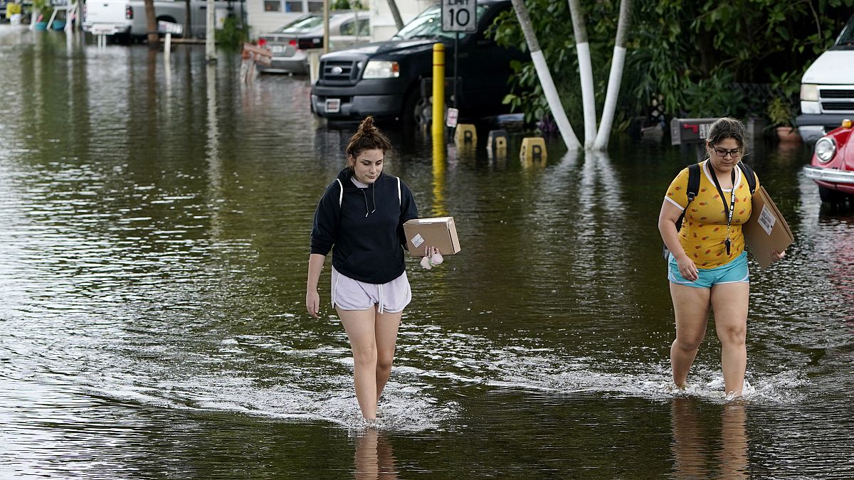 Dos mujeres caminan por las calles inundadas en Davie, Florida
