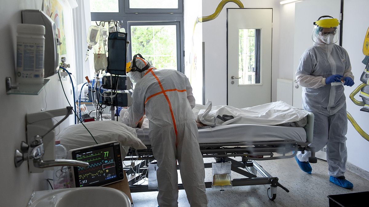 Védőfelszerelést viselő orvos és ápoló ellát egy beteget a koronavírussal fertőzött betegek fogadására kialakított osztályon