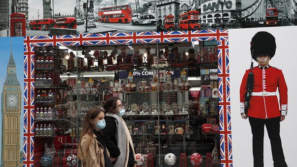 Shoppers walk past a shop window in Oxford Street, London, Tuesday, Oct. 13, 2020. Shoppers walk past a shop window in Oxford Street, London, Tuesday, Oct. 13, 2020.