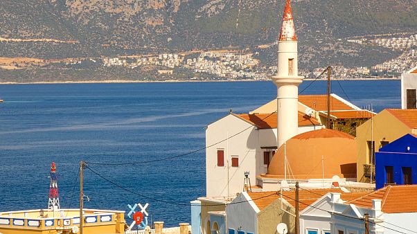 L'antica moschea di Kastellorizo. Sullo sfondo, le le case di Kas, in Turchia L'antica moschea di Kastellorizo. Sullo sfondo, le le case di Kas, in Turchia