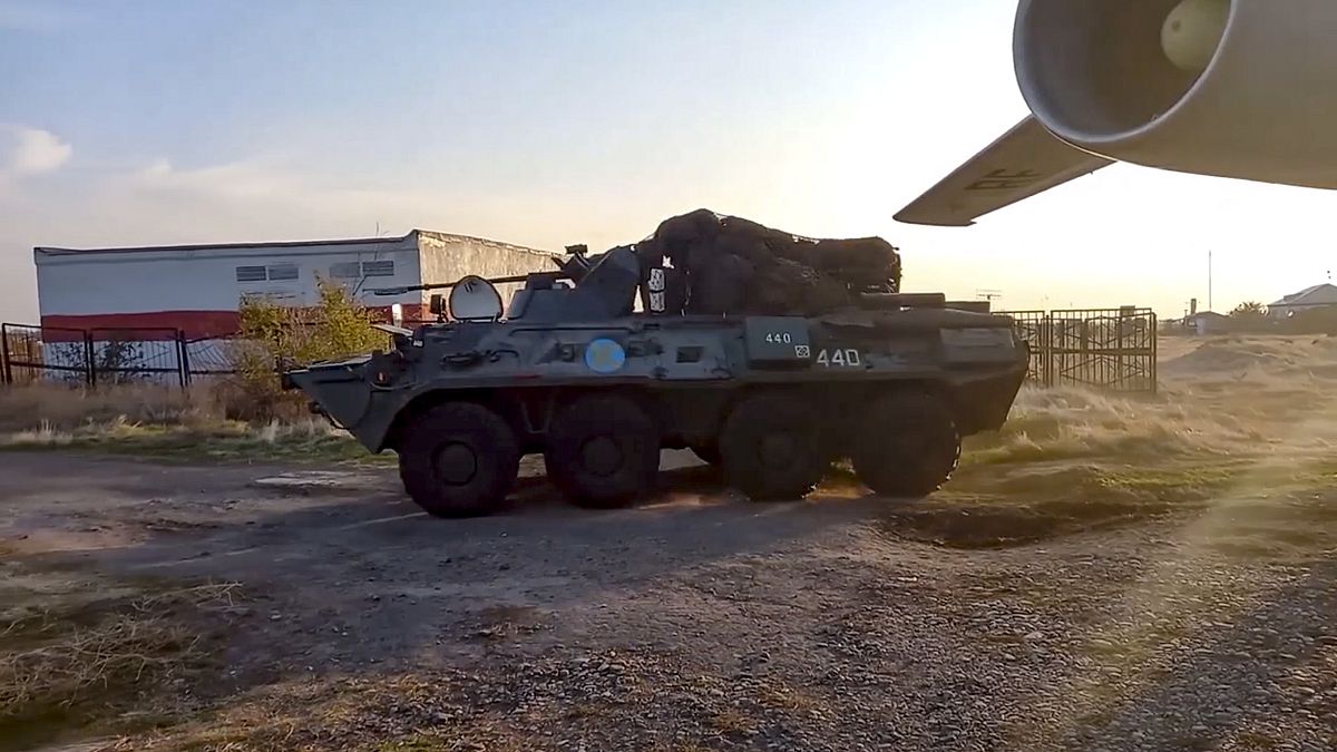Russian military vehicle rolls past a military cargo plane at an airport outside Yerevan, Armenia.
