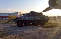 Russian military vehicle rolls past a military cargo plane at an airport outside Yerevan, Armenia.