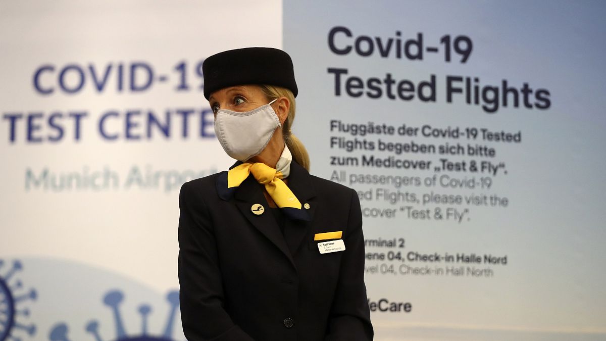 Una azafata se para frente a la entrada de un nuevo centro de pruebas rápidas de coronavirus de Lufthansa en el aeropuerto de Múnich.