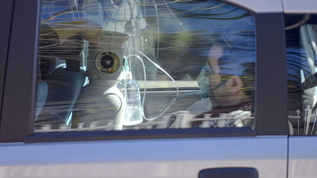 Un hombre recibe oxígeno en un coche aparcado fuera del Hospital Cotugno de Nápoles