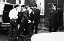 Peter William Sutcliffe (blanket on head) in Dewsbury in February 1981, where at the Magistrates Court he was committed in custody for trial on 13 counts of murder.