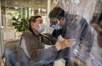 Relatives at a nursing home in Italy hug each other through a plastic film screen to avoid contracting COVID-19