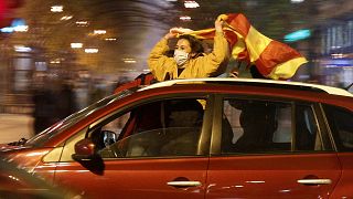 People drive cars and wave national flags celebrating the nation's qualification for EURO 2020, in a street in Skopje, North Macedonia, late Thursday, Nov. 12, 202O.