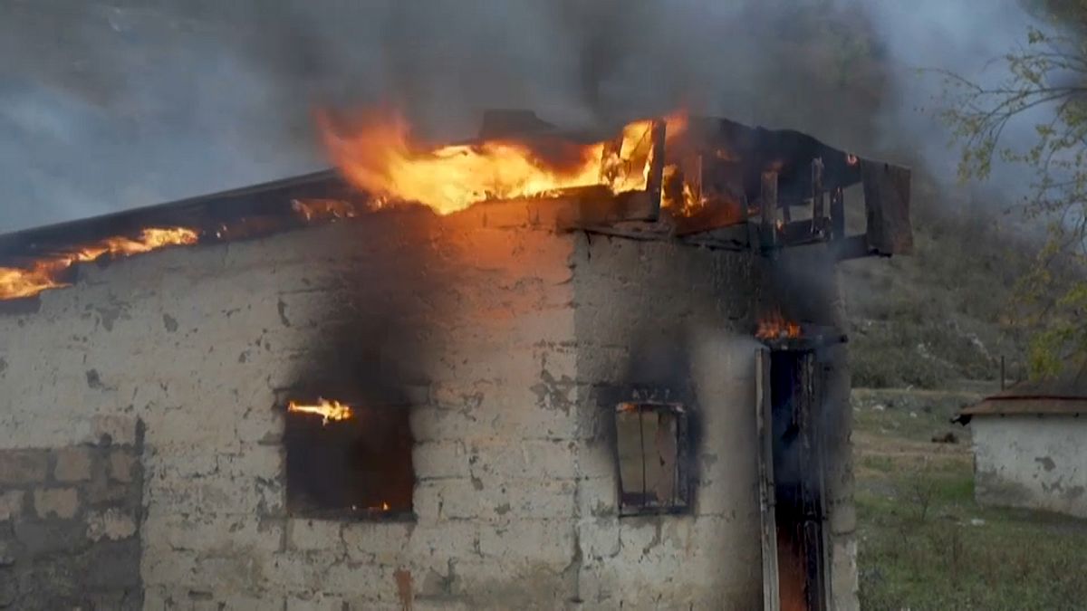 Una casa en llamas en la zona que Azerbaiyán recuperará tras el acuerdo de paz negociado por Rusia