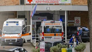 Cars and ambulance wait outside the Infectious Disease first aid area of the Cardarelli hospital in Naples.