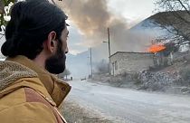 A resident in the town of Karvachar watches his home burn after setting it on fire