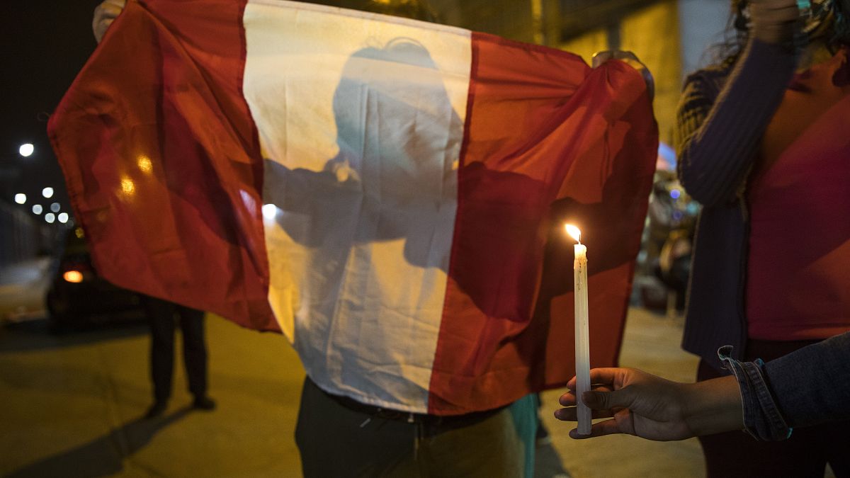 Una manifestante contra el Gobierno sujeta una bandera peruana
