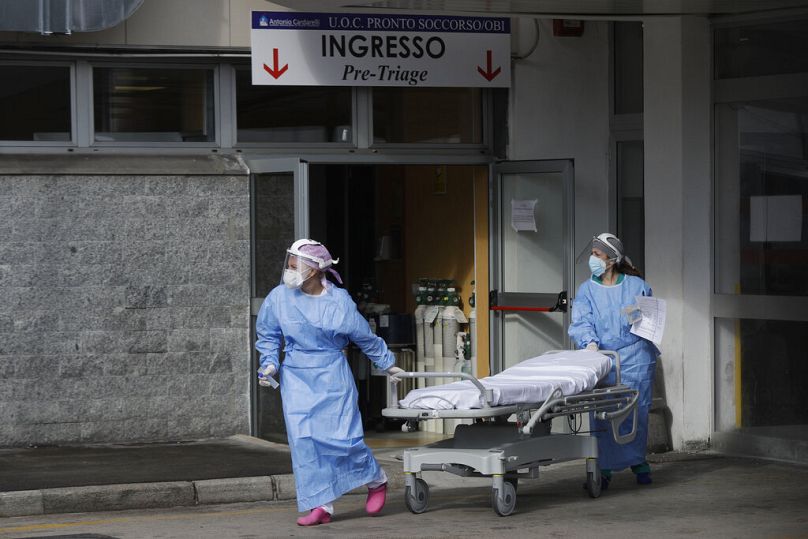 Paramedics and doctors stand outside the first aid area of the Cardarelli hospital in Naples, Italy, Friday, Nov. 13, 2020.