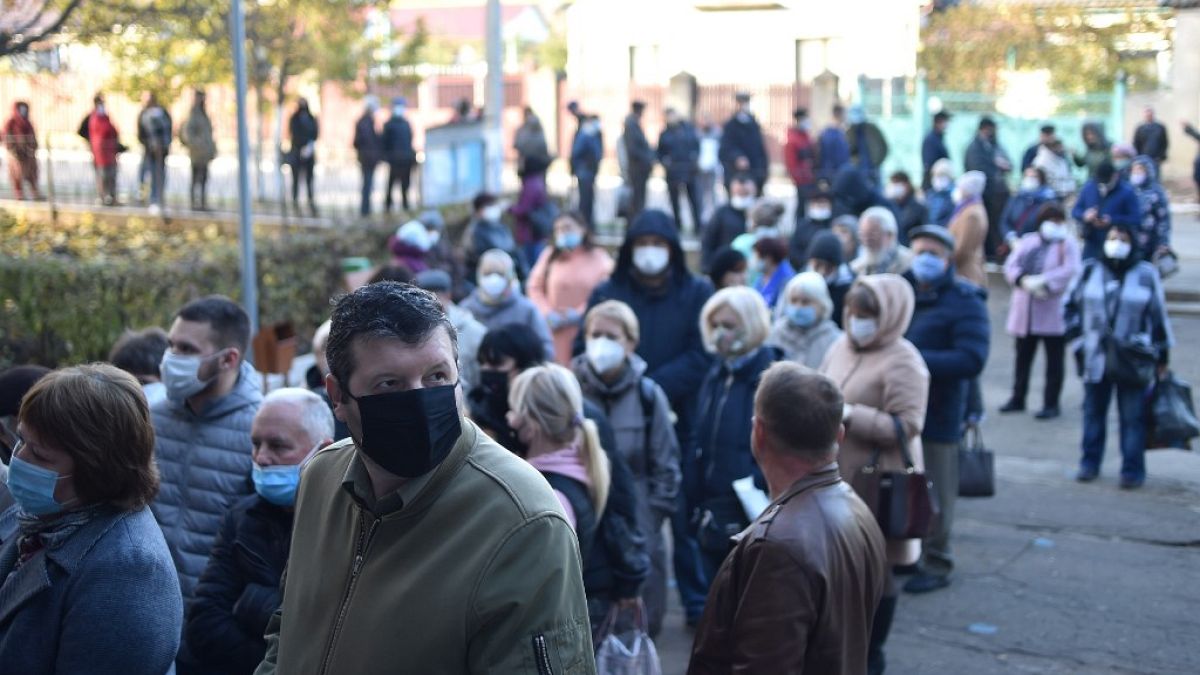 People wearing face masks queue at a polling station during the second round of Moldova's presidential election in the town of Varnita at Moldova - Transnistrian border