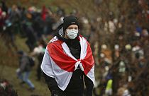 A demonstrator covering himself with an old Belarusian national flag stands during an opposition rally to protest the official presidential election results in Minsk, Belarus,