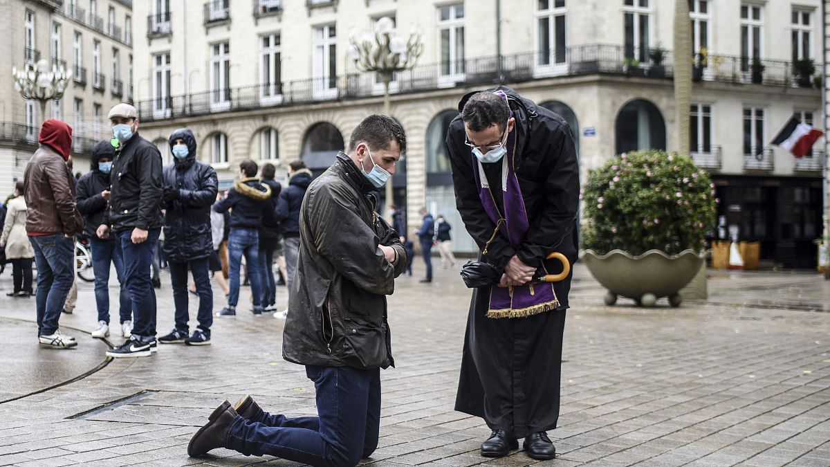 Un prêtre catholique écoute un fidèle dans la rue à Nantes, France le 15 novembre 2020