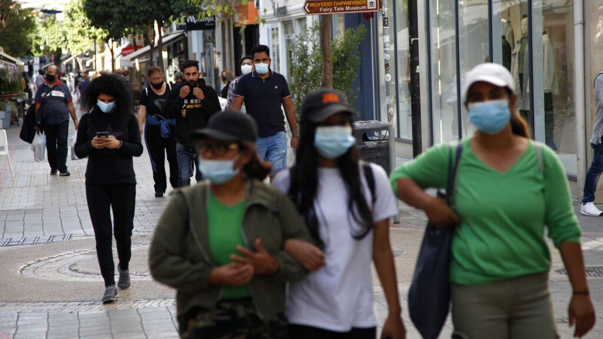 People wearing masks walk along Ledra street, a main shopping street in down town Nicosia