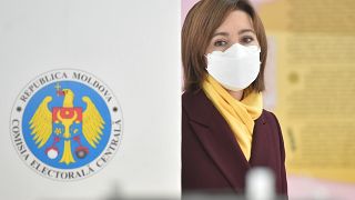 Presidential candidate Maia Sandu wearing a face mask walks to cast her ballot at a polling station during the second round of Moldova's presidential election in Chisinau.