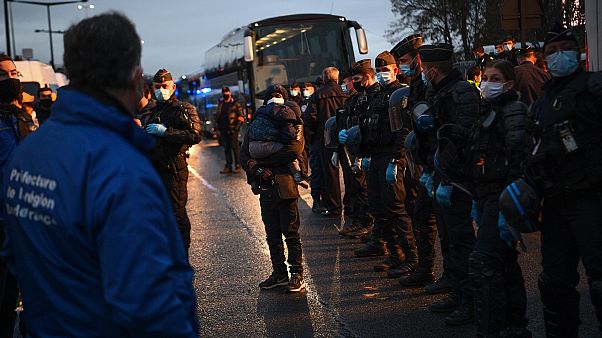 Migrants wait to be evacuated by Gendarmerie forces at a makeshift camp set below the motorway in Saint-Denis, France, on Nov. 17, 2020. Migrants wait to be evacuated by Gendarmerie forces at a makeshift camp set below the motorway in Saint-Denis, France, on Nov. 17, 2020.