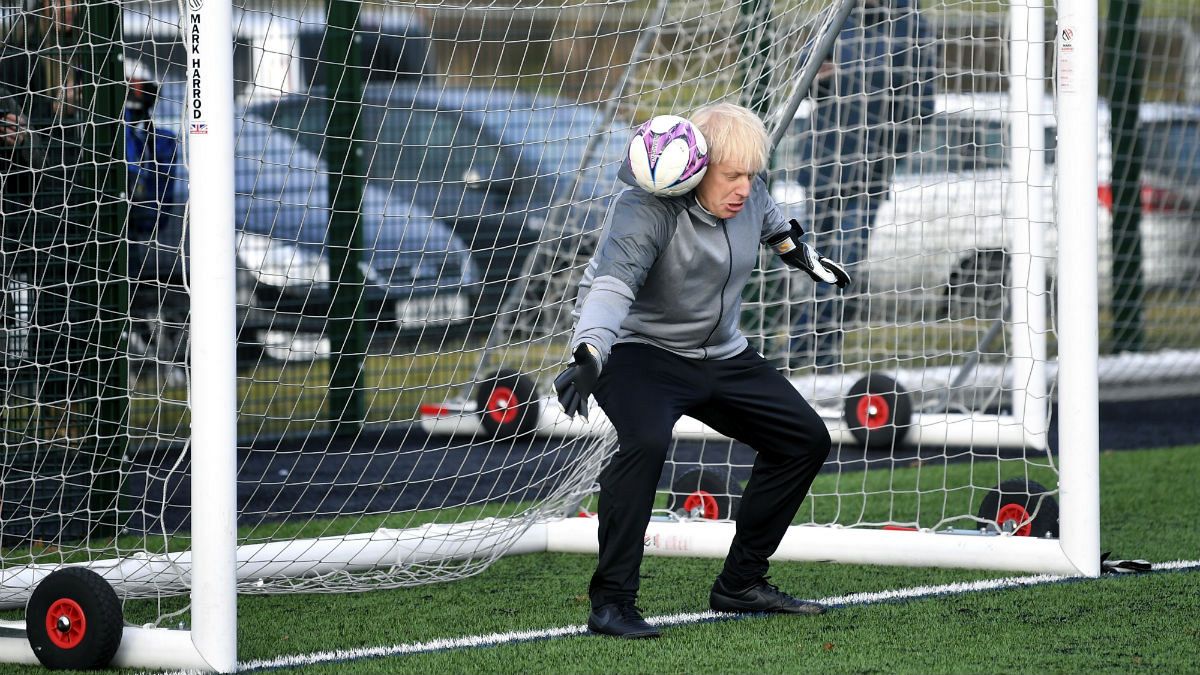 بوریس جانسون، نخست وزیر بریتانیا در حال دروازه‌بانی در یک مسابقه فوتبال دختران نوجوانان، دسامبر ۲۰۱۹