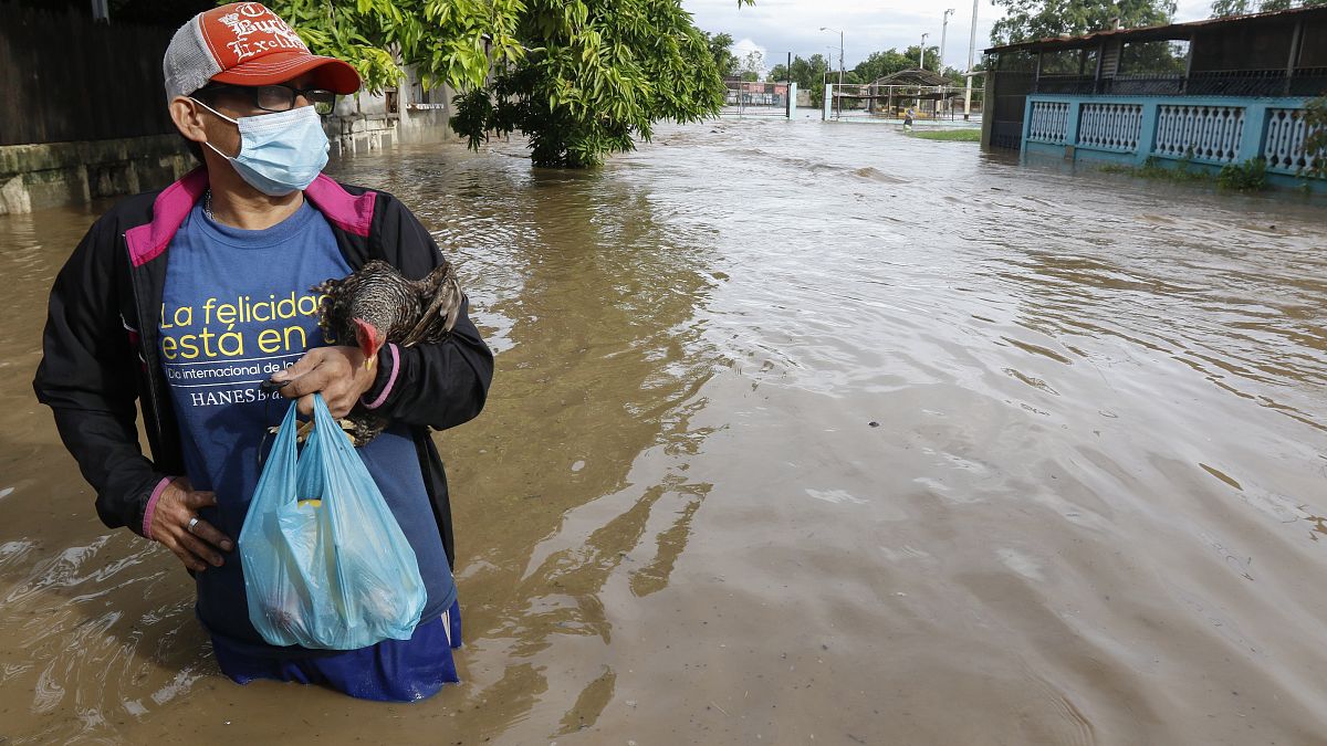 Un residente está parado en una calle inundada de agua en el vecindario de Planeta, Honduras, el 5 de noviembre de 2020.