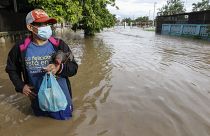 Un residente está parado en una calle inundada de agua en el vecindario de Planeta, Honduras, el 5 de noviembre de 2020.