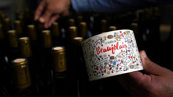 Tuesday, Nov. 12, 2019, a man picks a bottle of Beaujolais Nouveau in the Vinescence cellar in Saint Jean d'Ardieres, in the Beaujolais region Tuesday, Nov. 12, 2019, a man picks a bottle of Beaujolais Nouveau in the Vinescence cellar in Saint Jean d'Ardieres, in the Beaujolais region