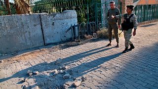 Security forces inspect the scene of the rocket attack at the gate of al-Zawra public park in Baghdad, Iraq, Wednesday, Nov. 18, 2020.