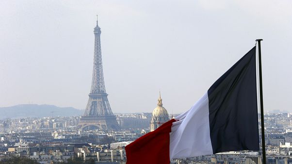 The French flag above the skyline of the French capital with the Eiffel Tower. The French flag above the skyline of the French capital with the Eiffel Tower.