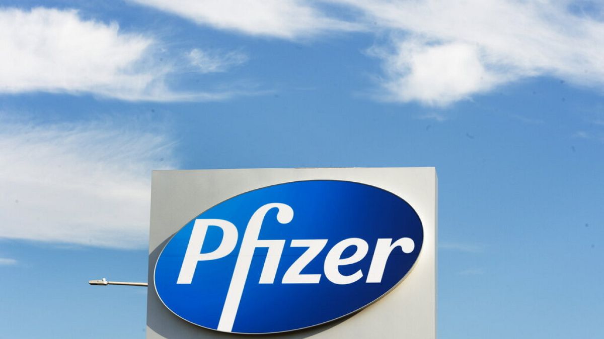  a sign with the Pfizer logo stands outside the corporate headquarters of Pfizer Canada in Montreal.