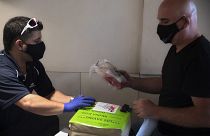 Dorme negli aeroporti vuoti e riparte subito dopo la consegna per evitare la quarantena: Mishel Zrian, corriere israeliano (a dx) riceve il midollo osseo da trasportare.
