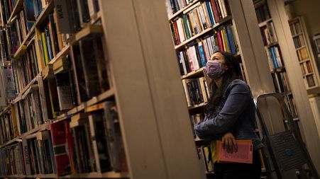 A woman wears a face mask, to protect against the spread of coronavirus, as she browses for books in a second-hand bookshop in Brussels, June 11, 2020.