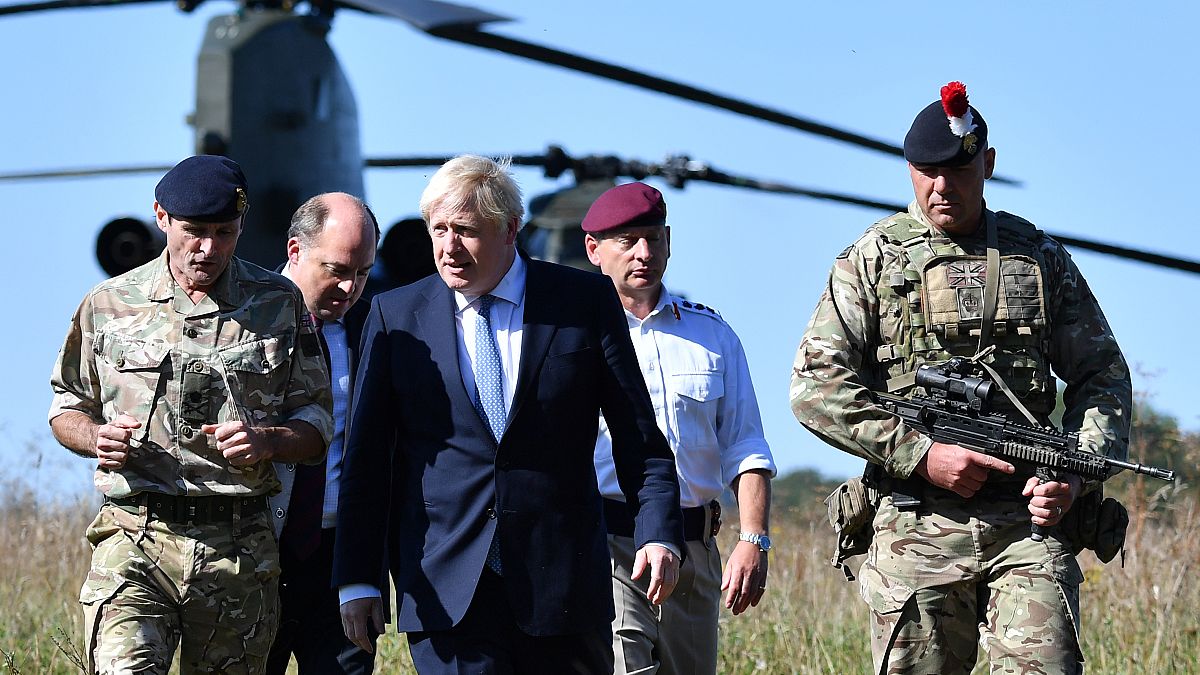 بوريس جونسون  مع وزير الدفاع البريطاني بن والاس في منطقة تدريب سهل سالزبوري بالقرب من سالزبوري، جنوب غرب إنكلترا