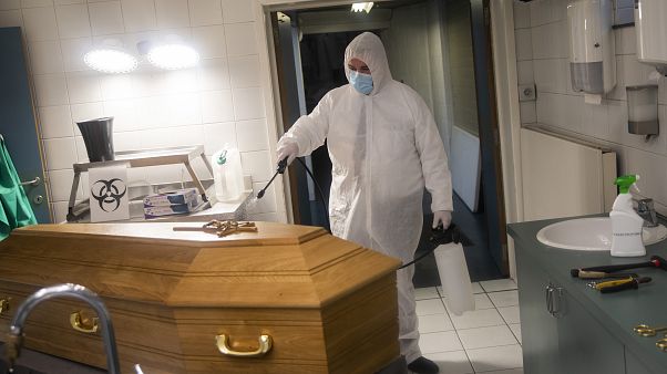 A worker, wearing a full protective equipment, disinfects the casket of someone who died of coronavirus COVID-19 at a funeral home in Charleroi, Belgium, Nov 17, 2020. A worker, wearing a full protective equipment, disinfects the casket of someone who died of coronavirus COVID-19 at a funeral home in Charleroi, Belgium, Nov 17, 2020.