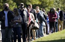 Voters brave a bright sun as they wait to cast their ballots in Mississippi, US.