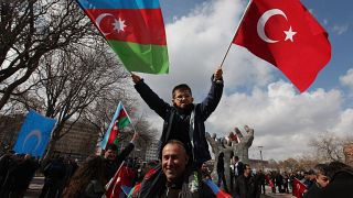 Un bambino turco sventola la bandiera della Turchia e dell'Azerbaijan