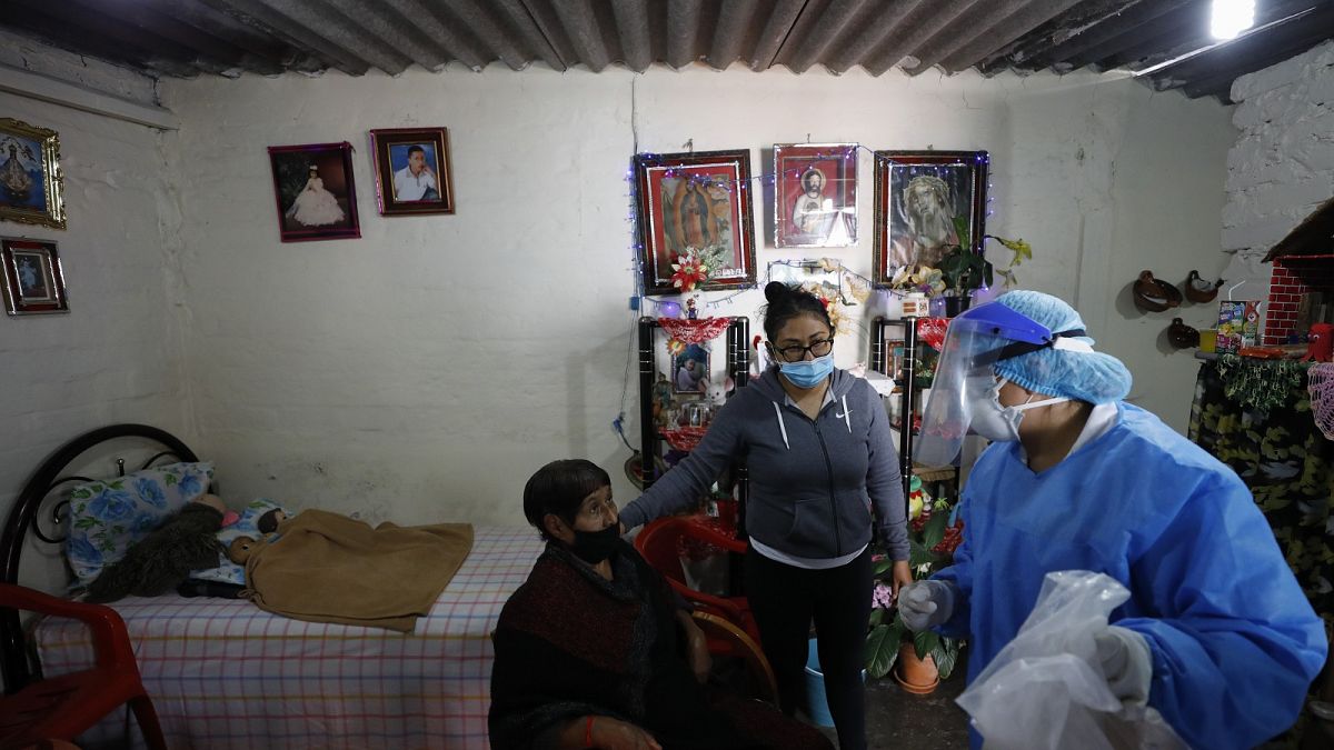 Dr Delia Caudillo, right, gives medical guidance to 82-year-old Modesta Caballero, left, after a medical team tested Caballero for COVID-19 at her home in Mexico City.