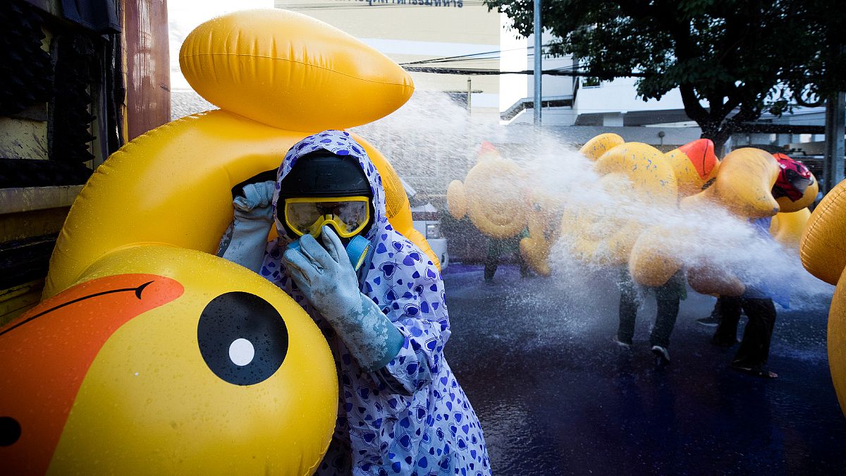 Protesters take cover with inflatable ducks as police fire water cannon during an anti-government rally near the parliament in Bangkok, Thailand. November 17, 2020