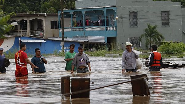 Hombres caminan por una calle inundada después del paso del huracán Iota en La Lima, Honduras Hombres caminan por una calle inundada después del paso del huracán Iota en La Lima, Honduras