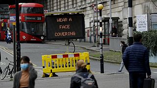 A sign is displayed outside London's Waterloo train station to remind people thy are required to wear face coverings inside the station 