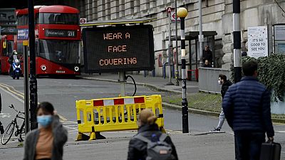 A sign is displayed outside London's Waterloo train station to remind people thy are required to wear face coverings inside the station 