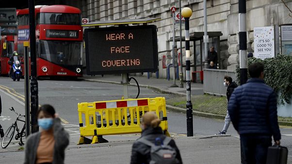A sign is displayed outside London's Waterloo train station to remind people thy are required to wear face coverings inside the station A sign is displayed outside London's Waterloo train station to remind people thy are required to wear face coverings inside the station