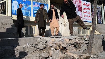 Residents gather at a site after several rockets land at Khair Khana, north west of Kabul.