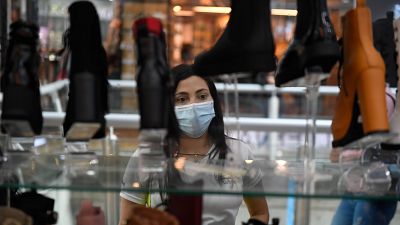 A woman looks at a store window advertising Black Friday discounts at a shopping centre in Caracas, Venezuela.