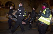 Polizisten nehmen einen Demonstranten fest