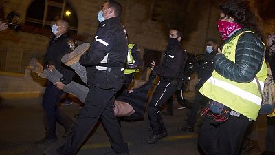 Polizisten nehmen einen Demonstranten fest